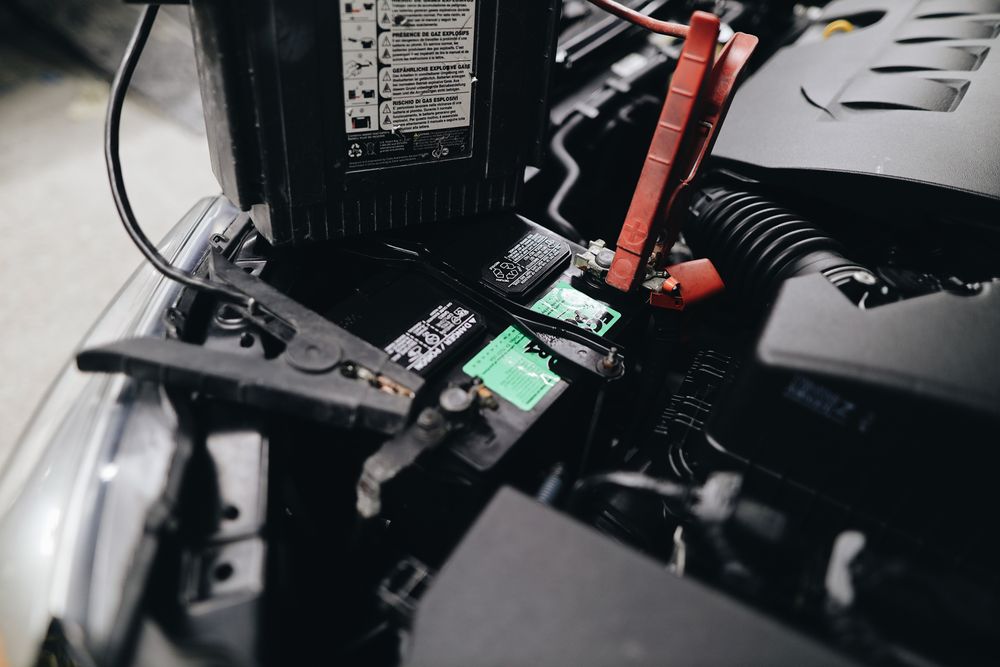 Battery terminals and connected jumper cables in an engine bay