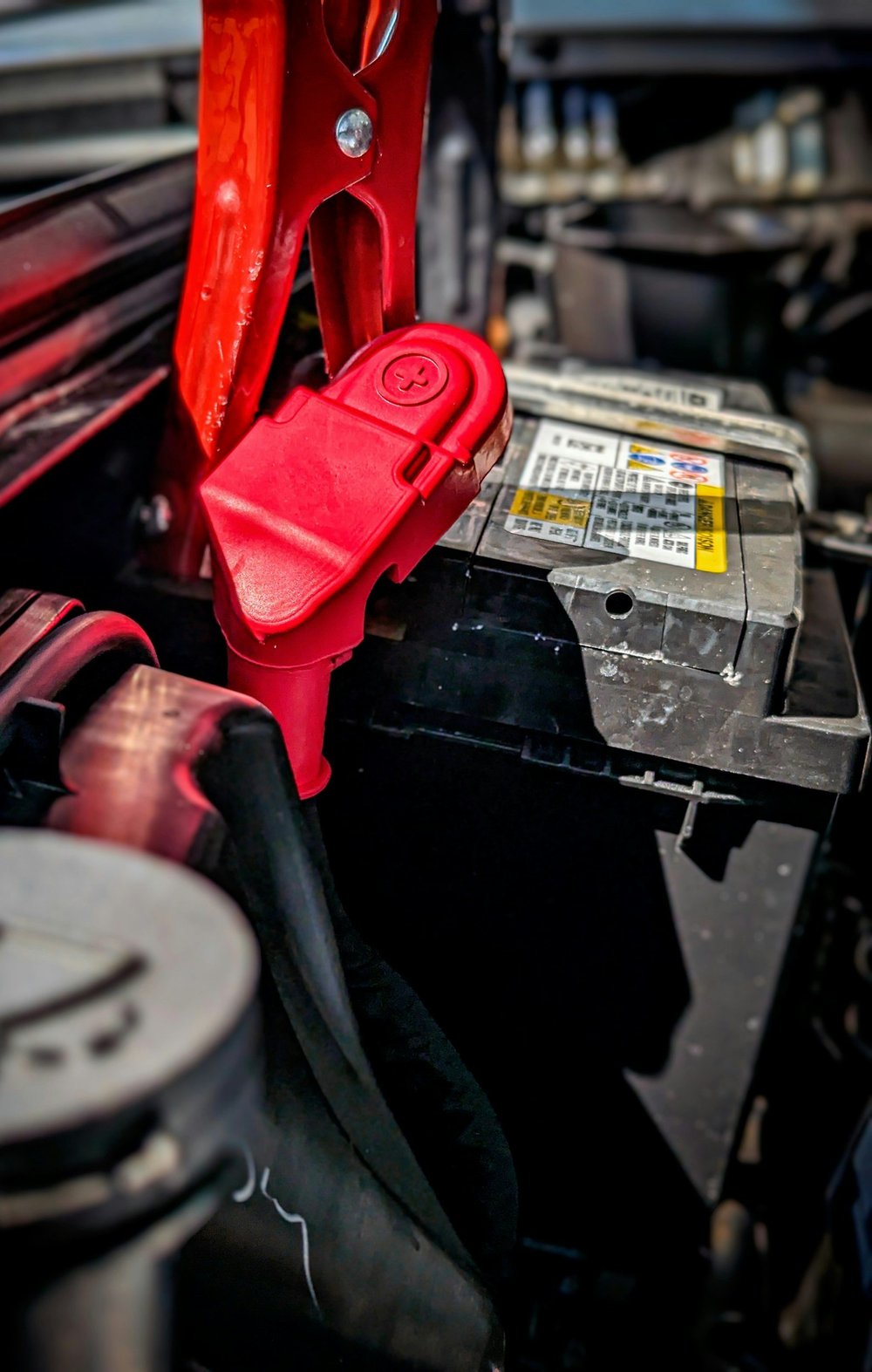 Car battery installed under the hood