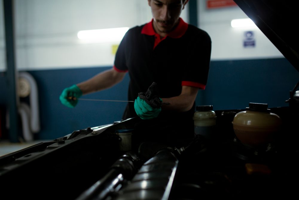 Technician inspecting the engine oil level with a dipstick