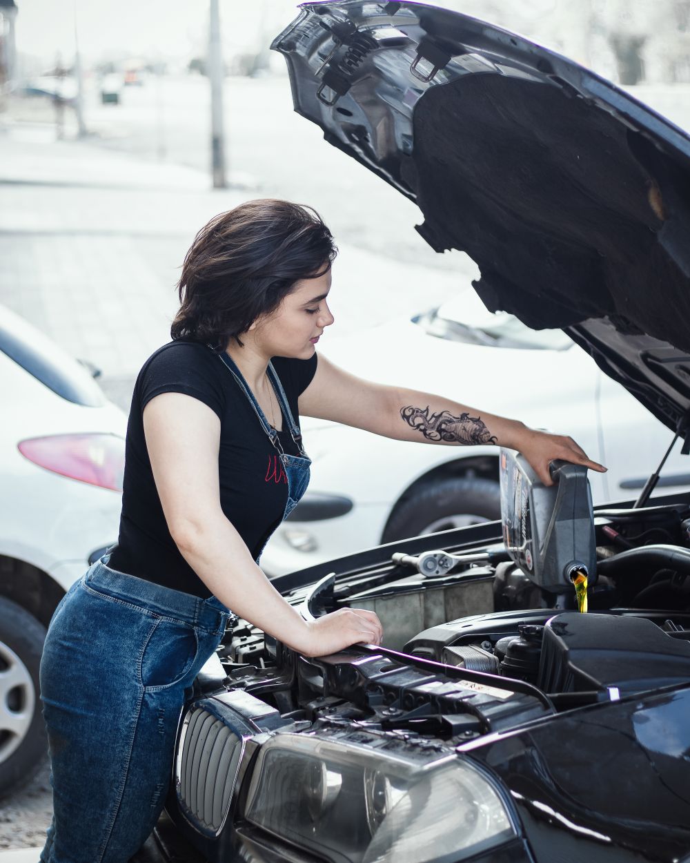Oil being added to a car engine outdoors